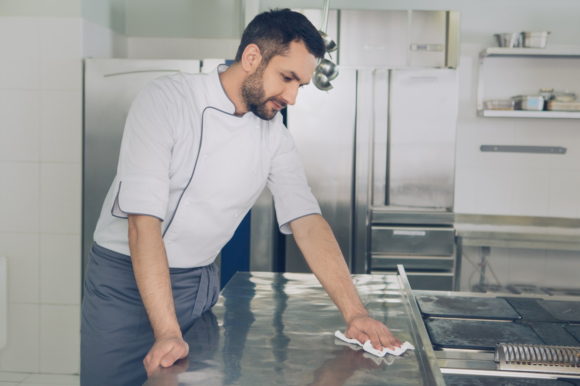 Medewerker reinigt een werkblad in een voedingsproductie