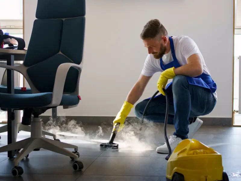 Schoonmaker met een schrobmachine in een kantoorpand