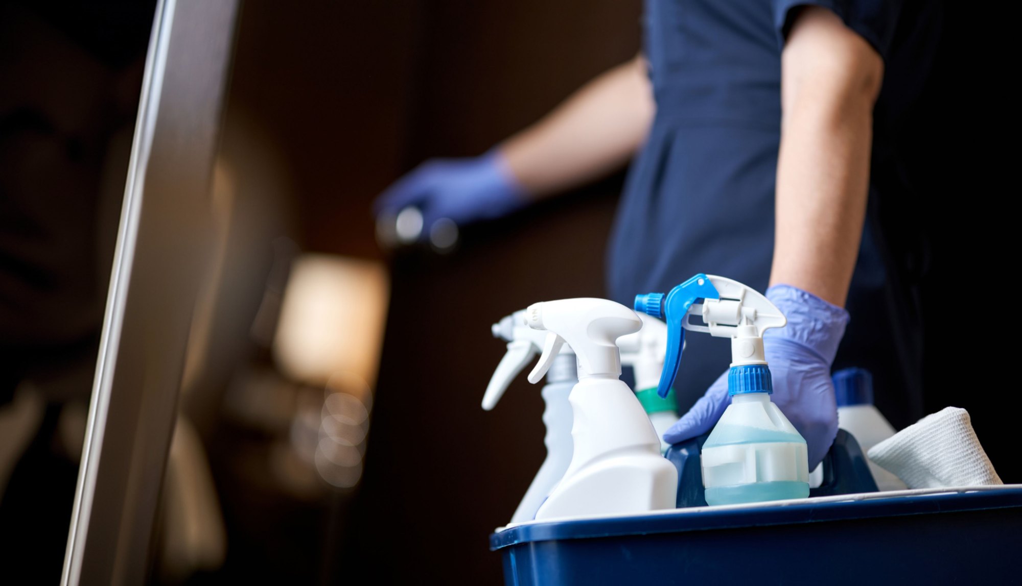 Sprayflessen in een schoonmaakkar